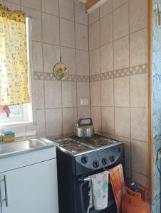 een keuken met een fornuis met een pot erop bij Cabañas Sandra Bucalemu Alto in Bucalemu +7 foto's
