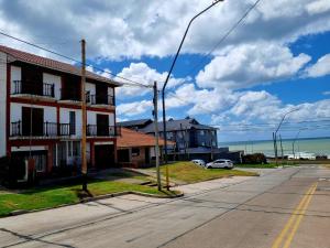 een lege straat met huizen en de oceaan bij Chalet del Faro in Mar del Plata
