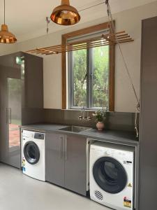 een keuken met een wasmachine en een wastafel bij Rosewood Terrace in Bathurst