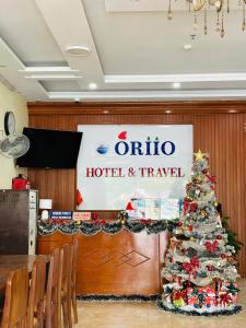 a christmas tree in front of a hotel and travel sign at Oriio Hotel in Cat Ba