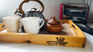 a wooden tray with cups and a kettle and a toaster at Nuestro Lugar in El Bolsón