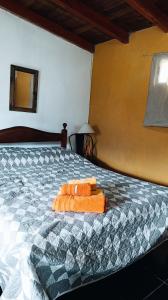 een slaapkamer met een bed met oranje handdoeken erop bij Nuestro Lugar in El Bolsón