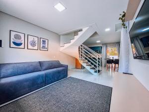 ein Wohnzimmer mit einem blauen Sofa und einer Treppe in der Unterkunft Casa Nova e Completa | 2 Suítes com Ar | Área Gourmet | 2 Vagas in Brusque