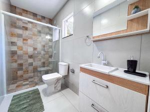 ein Badezimmer mit Toilette, Waschbecken und Dusche in der Unterkunft Casa Nova e Completa | 2 Suítes com Ar | Área Gourmet | 2 Vagas in Brusque + 25 Fotos