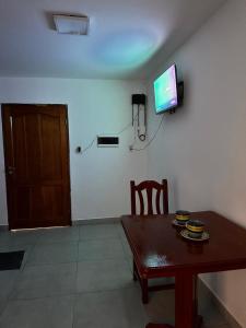 a dining room with a table and a television on a wall at Habitación Privada in Libertador General San Martín
