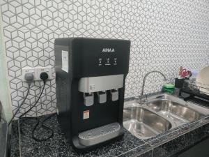 une cafetière posée sur un comptoir à côté d'un évier dans l'établissement Seri Mersing Villa, à Mersing