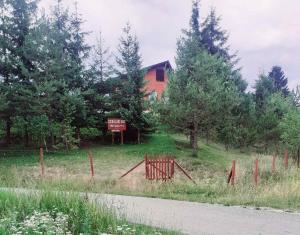Ein Zaun auf einem Feld neben einem Haus in der Unterkunft Mountain resort house - Planinska vikendica in Han Pijesak
