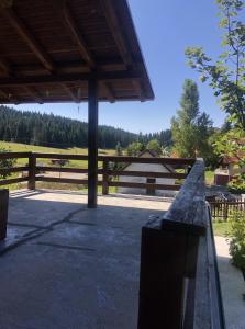 eine Veranda mit Holzzaun und ein Feld in der Unterkunft Mountain resort house - Planinska vikendica in Han Pijesak