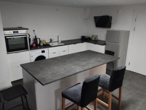 a kitchen with a counter with chairs and a refrigerator at Möblierte Zimmer in privater Wohnung in Köln Heimersdorf in Cologne