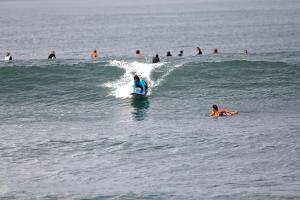 Eine Person, die eine Welle auf einem Surfbrett im Ozean reitet in der Unterkunft Villa Paz Bali in Canggu
