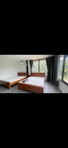 two beds in a room with a window at Thiên Vy Homestay in Phu Quoc