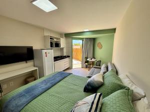 une chambre avec un grand lit et une cuisine dans l'établissement Max Carneiros Suítes - Com e sem piscina privativa, à Praia dos Carneiros