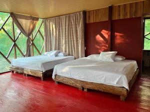 2 letti posti in una stanza con finestre di Tekuna a Leticia