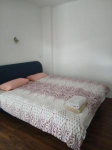 ein Bett mit einer rosa-weißen Bettdecke und zwei Büchern in der Unterkunft Sokak in Struga