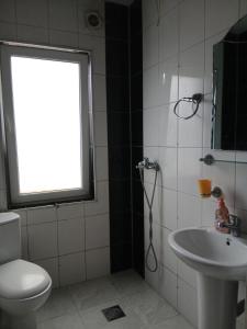 a bathroom with a toilet and a sink and a window at Sokak in Struga