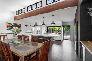 a kitchen and dining room with a table and chairs at Summit to Sea, Elevated Luxury in Coolum Beach +21 photos