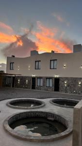 ein Gebäude mit zwei großen Brunnen davor in der Unterkunft Aroma a Vi d Fiambalá in Fiambala