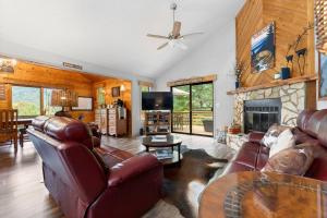 ein Wohnzimmer mit Ledermöbeln und Kamin in der Unterkunft Bella Vita - Pet Friendly Cabin in Maggie Valley