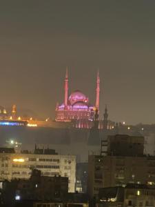 Ein Gebäude mit einer violetten Kuppel in einer Stadt bei Nacht in der Unterkunft Nada HOTEL in Kairo