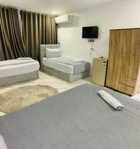 ein Zimmer mit zwei Betten und einem Flachbildfernseher in der Unterkunft Nada HOTEL in Kairo