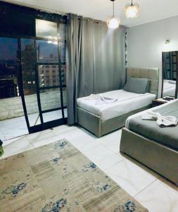ein Schlafzimmer mit zwei Betten und einem großen Fenster in der Unterkunft Nada HOTEL in Kairo