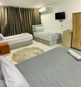 ein Hotelzimmer mit zwei Betten und einem Fernseher in der Unterkunft Nada HOTEL in Kairo + 10 Fotos