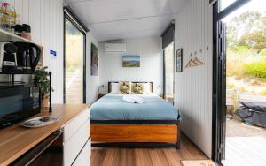 een slaapkamer in een tiny house met een bed bij Kūkupa Puni at Akaroa Lavender by Tiny Away in Akaroa