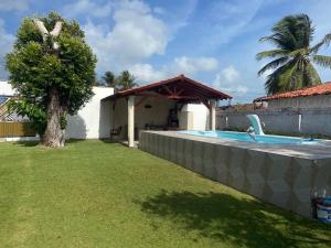a backyard with a swimming pool and a house at Casa Relaxante in Salinópolis