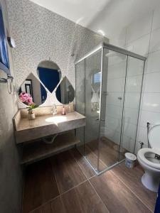 a bathroom with a sink and a shower and a toilet at Pousada Villa Santorini Preá in Cruz
