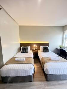 a room with two beds in a room at Mango Suites - Angeles in Angeles