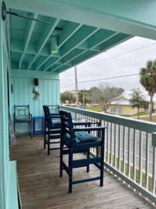 a porch with two chairs and a table at Cedar Key Islands Dolphins Cay Condo in Cedar Key