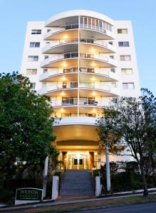 a large white building with stairs leading up to it at Founda Gardens Apartments in Brisbane