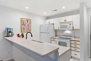 a kitchen with white cabinets and a white refrigerator at Modern Fishing Lodge 8ppl in Branson