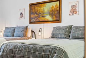 a bedroom with two beds and a painting on the wall at Modern Fishing Lodge 8ppl in Branson