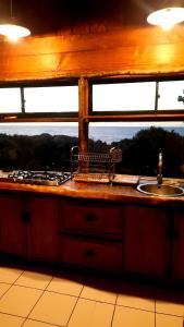 een keuken met een aanrecht met een wastafel en een raam bij Refugio Kallfuko, a great space with nature in Valdivia