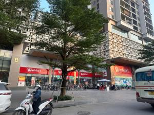 una persona che guida uno scooter di fronte a un edificio di Hoà Bình 505TK21 a Hanoi