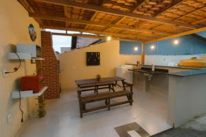 a kitchen with a wooden table and a sink at Loft central perto da praia in Caraguatatuba