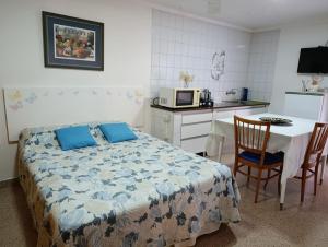een slaapkamer met een bed en een keuken met een tafel bij Remanso Cochera opcional in Bahía Blanca