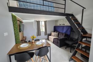 a living room with a dining table and a loft bed at Loft central perto da praia in Caraguatatuba