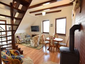 een woonkamer met een trap en een tafel en stoelen bij Holiday apartment with fireplace, lake view in Kiedrowice