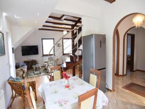 een eetkamer en woonkamer met een tafel en stoelen bij Holiday apartment with fireplace, lake view in Kiedrowice