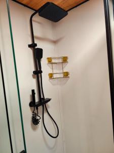 una doccia in un bagno con una luce nera sul muro di Village Hakuna a Balneário Gaivotas