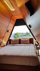 una camera da letto con un letto grande con una grande finestra di Village Hakuna a Balneário Gaivotas