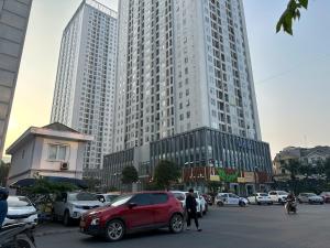 a red car parked in front of a tall building at Đại Dương Xanh 502TDH204 in Hanoi