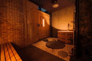 a bathroom with a tub and a sink and a bench at One Harajuku: Private Oasis in Tokyo