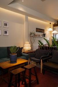 un soggiorno con divani, tavoli e piante di Nap Old Town a Bangkok