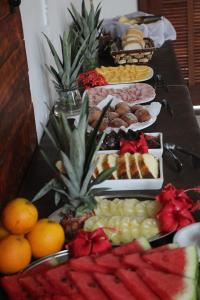 a long buffet of food with fruit on a table at L Grace Centro in Búzios +10 photos