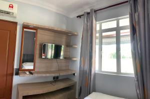 a room with a tv and a mirror and a window at Single Room 2 Bed in Papar