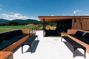 a patio with benches and a view of a field at Sethachan Poolvilla Khaoyai in Ban Rai Khlong Sai