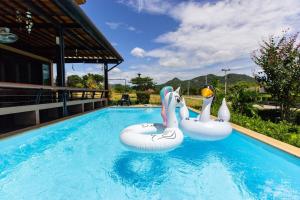 two inflatable swans in a swimming pool at Sethachan Poolvilla Khaoyai in Ban Rai Khlong Sai